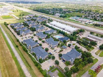 A bird's eye view of a residential area with houses and a highway.